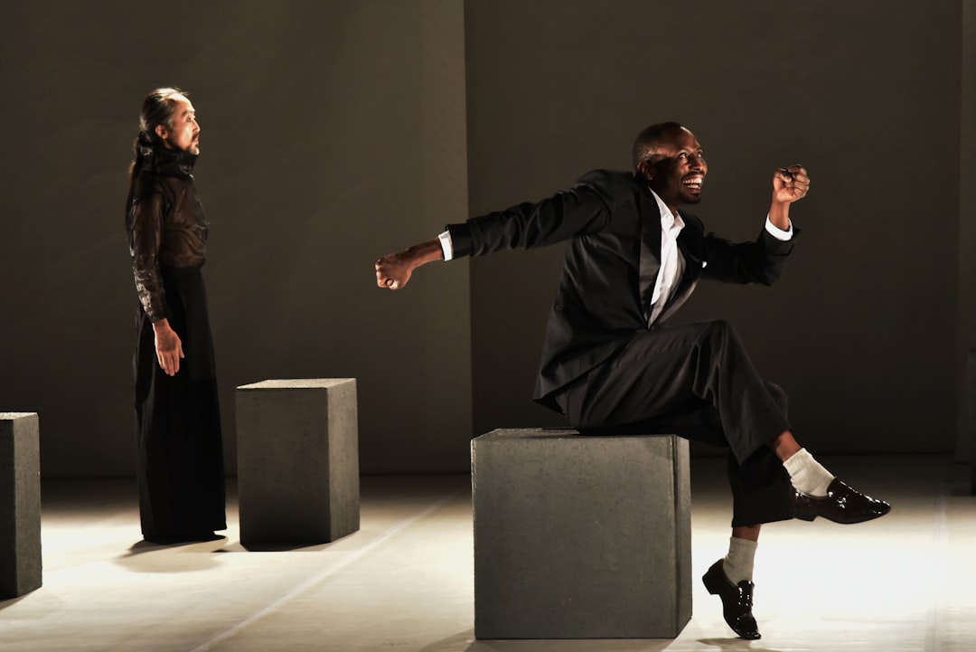 man-in-black-suit-sitting-on-gray-chair-cyryu0b-o4i